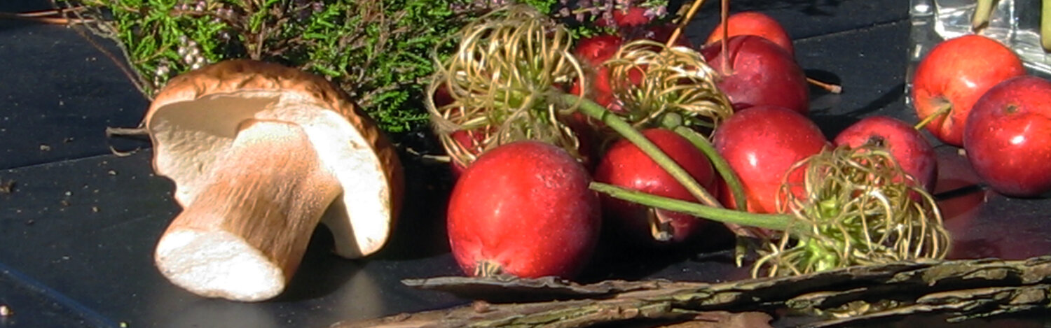 Typische herfstdecoratie op een tafel: appels, een paddenstoel, heide