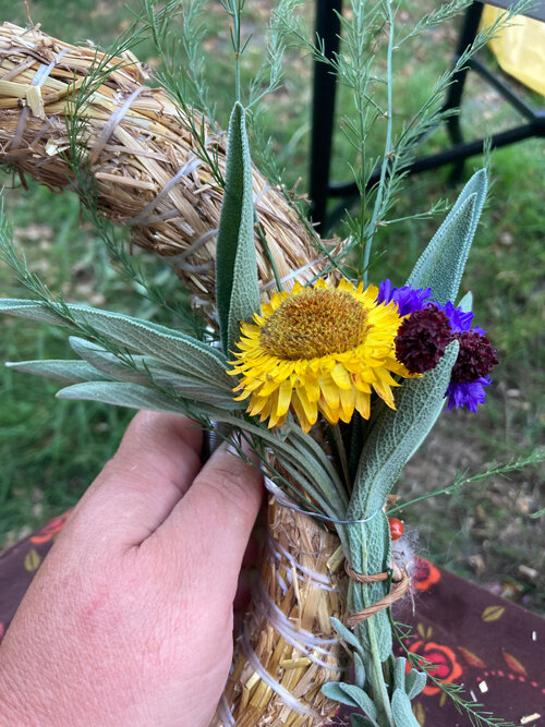 Krans binden: een klein boeketje bloemen en bladeren wordt op een strokrans gebonden