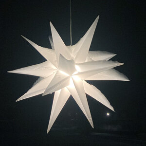 Verlichte witte adventsster in het donker